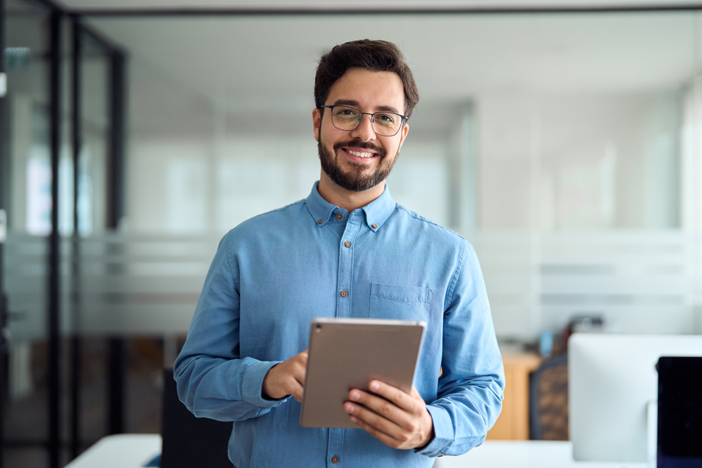 young professional smiling while holding tablet