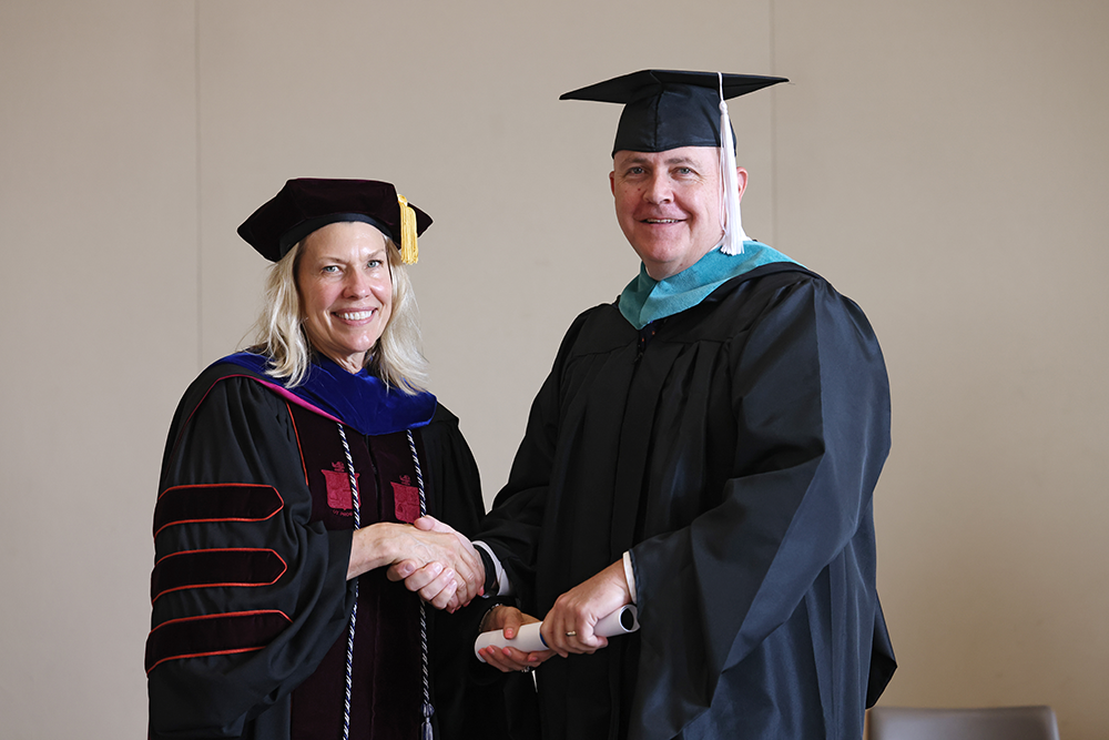 Christopher Easton shaking hands while receiving his diploma