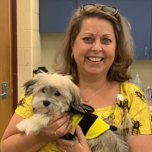 Libby Nicholson smiling holding a dog.